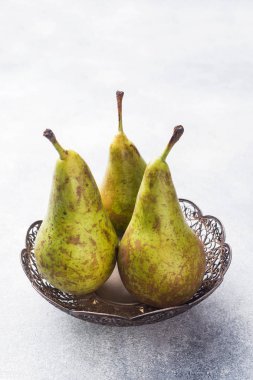 Gri bir arka plan üzerinde bir sepet içinde taze sulu armut konferans