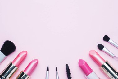 Profesyonel makyaj araçları. Fırçalar ruj allık göz gölge kopya alanı bir pembe pastel zemin üzerine. Düz yatıyordu.