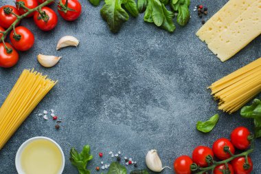 Ham İtalyan makarna spagetti ve malzemeyi kiraz domates peynir yeşillik yemek. İtalyan yemeği koyu taş arka plan. Kopya alanı ile Üstten Görünüm.