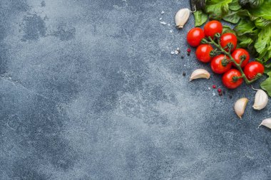 Kiraz domates ile baharat kopya alanı karanlık taş masa üst görünümüyle bir dal taze otlar ve sarımsak karanfil