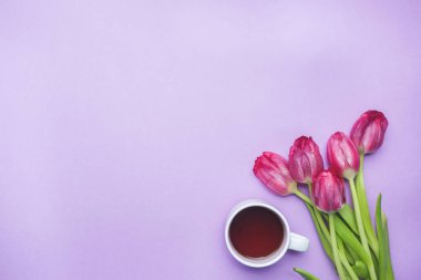 Lale ve bir fincan kahve pembe bir arka plan üzerinde buket. kopya alanı. Düz yatıyordu, en iyi görünümü