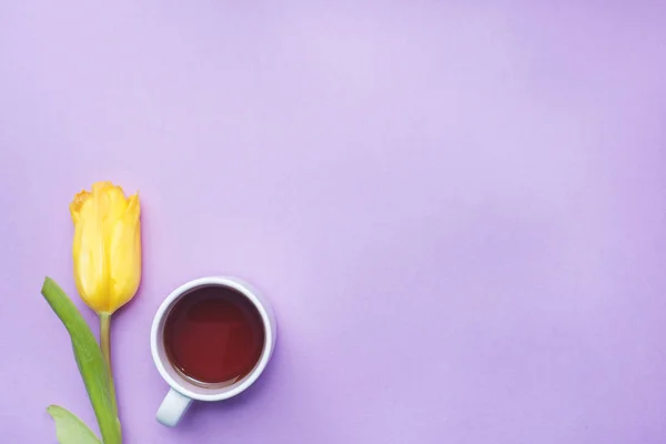 Bouquet of tulips and a Cup of coffee on a pink background. copy space. Flat lay, top view