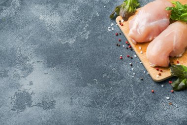 Otlar ve baharatlar kopya alanı ile koyu arka plan üzerinde çiğ tavuk göğsü fileto
