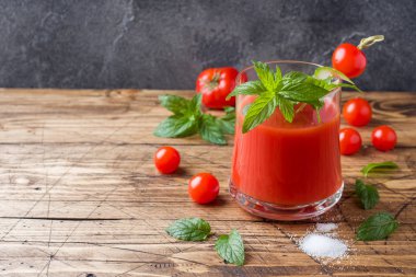 Domates suyu ile nane cam ve ahşap bir masa üzerinde taze domates. Sağlıklı organik gıda kavramı. Kopya alanı