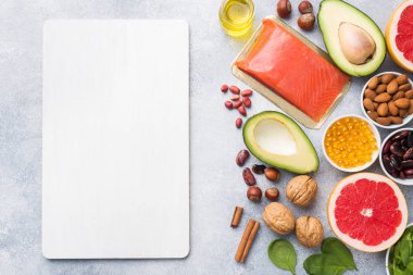 Sağlıklı gıda antioksidan ürünleri: balık ve avokado, fındık ve balık yağı, greyfurt ıspanak ve yağ üzerinde gri bir arka plan beton. kopya alanı.