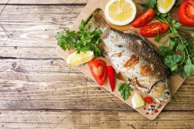 Pişmiş sazan balık sebze ve baharat alanının bir kopyasını bir ahşap tablo.