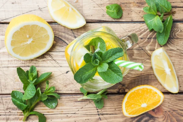 Lemonade drink of soda water, lemon and mint leaves in jar on wooden background. — Stock Photo, Image