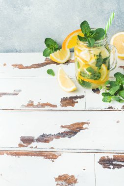 Limonata bardak maden suyu, limon ve nane kavanoza ışık arka plan üzerinde bırakır. Kopya alanı