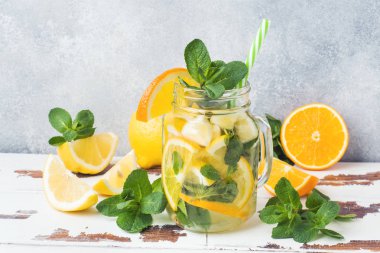 Limonata bardak maden suyu, limon ve nane kavanoza ışık arka plan üzerinde bırakır. Kopya alanı