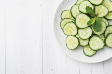 Dilimlenmiş salatalık ile nane bir plaka üzerinde. kavram diyet.