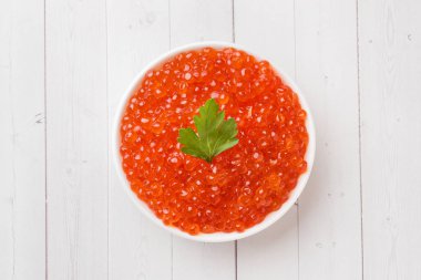 Kırmızı somon havyar beyaz masaya bir tabak içinde.