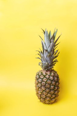 Sarı tonlu arka plan üzerinde olgunlaşmış ananas