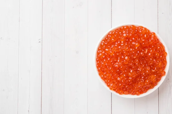 Red salmon caviar in a plate on a white table. Copy space — Stock Photo, Image