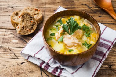 Ahşap kase taze otlar ile balık çorbası.