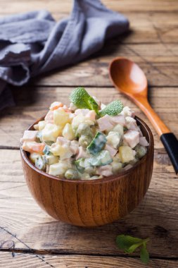 Geleneksel Rus Noel ve yeni yıl salata Olivier ahşap kase. Seçici odak