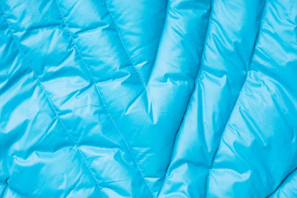 Primer plano sobre la textura de la chaqueta hinchable azul. Fondo de material acolchado — Foto de Stock