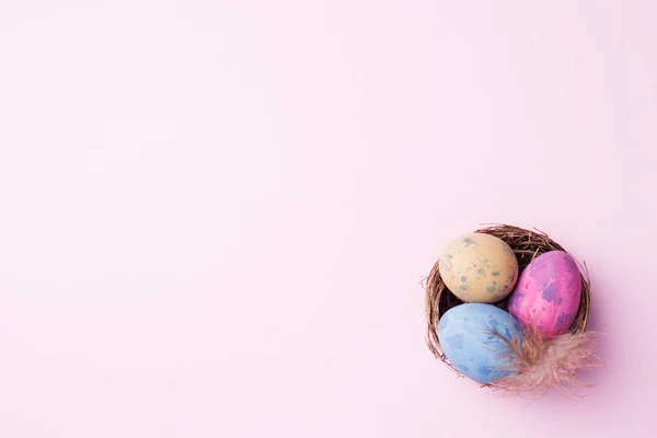 Uovo di Pasqua colorato nel nido su sfondo rosa con spazio per la copia. Sfondo pasquale. Minimalismo — Foto Stock