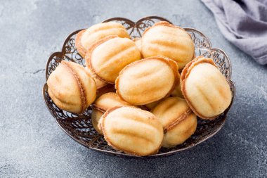 Karanlık bir arka planda haşlanmış yoğuşmalı süt ile ev yapımı Rus kurabiyeleri.