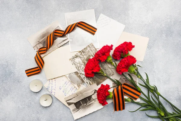 Postcard may 9 - red carnations Ribbon George Old photos on a concrete background. Symbol of victory in the great Patriotic war — Stock Photo, Image