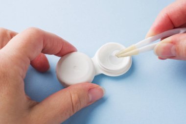 Lens depolama için kontakt lens ve Plastik Konteyner ile cımbız. Kapat şunu. Seçici odak.