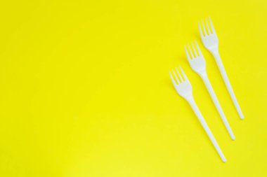 Kopya alanı ile parlak sarı arka planda tek kullanımlık plastik fişler.