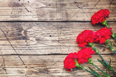 Kopya alanı ile ahşap arka planda kırmızı karanfil. Anneler günü kartı, Sevgililer günü.