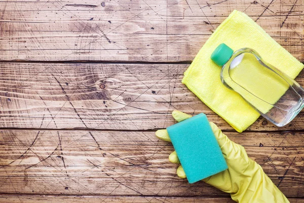 Tangan di sarung tangan kuning dan spons pembersih untuk membersihkan di latar belakang kayu. Konsep pembersihan rumah. Tampilan atas, ruang penyalinan — Stok Foto