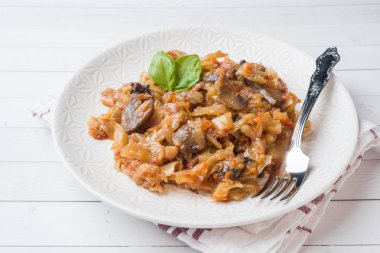 Beyaz ahşap arka plan üzerinde mantar ile haşlanmış lahana