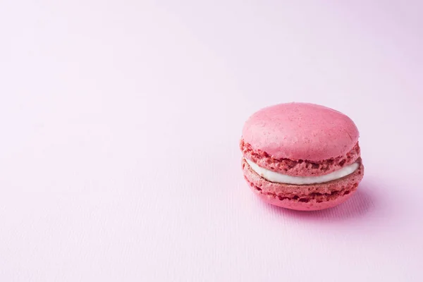 Roze dessert Macaron of bitterkoekjes op roze achtergrond. Selectieve focus. Ruimte kopiëren — Stockfoto