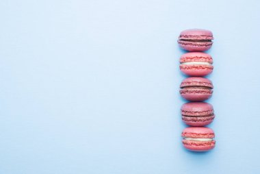 Mavi arka plan üst görünümünde pembe tatlı makarna veya makarna. Düz yatıyordu. Kopyalama alanı