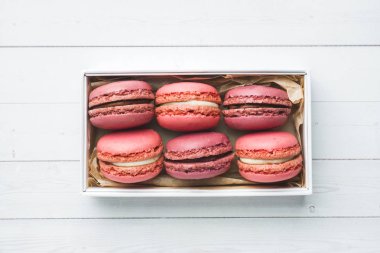 Pembe tatlı makarna veya beyaz bir arka plan üzerinde bir kutu içinde macaroons. Kopyalama alanı.