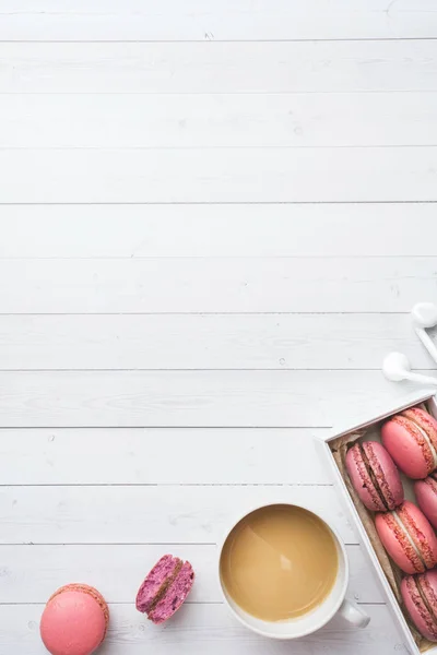 Taza de café, galletas de macarrones en una caja, flores sobre un fondo blanco. espacio de copia. concepto hermoso desayuno. plano laico — Foto de Stock