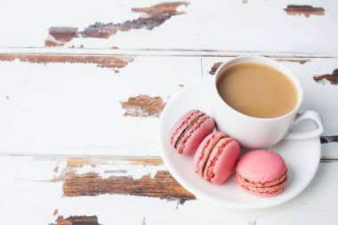 Beyaz arka plan daki bir tabakta bir fincan kahve ve makarna kurabiyesi. kopyalama alanı