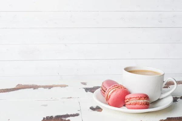 Tasse Kaffee und Makronenplätzchen auf einem Teller auf weißem Hintergrund. Kopierraum — Stockfoto