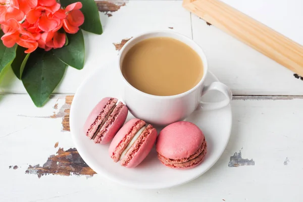 Tasse Kaffee und Makronenplätzchen auf einem Teller auf weißem Hintergrund. Kopierraum — Stockfoto