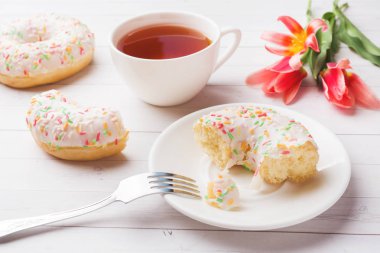 Çay ve çörekler Fincan, kopya alanı ile beyaz masada çiçek lale.