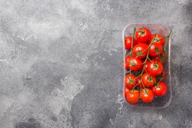 Koyu masaüzerinde küçük kırmızı kiraz domates, üst görünümü. Kopyalama alanı