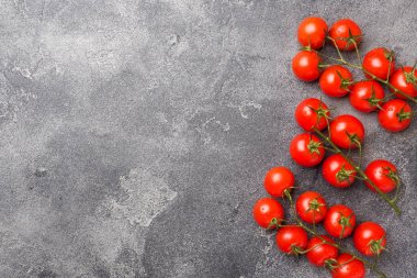 Koyu masaüzerinde küçük kırmızı kiraz domates, üst görünümü. Kopyalama alanı