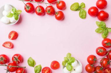 Caprese salatası için malzemeler. Fesleğen, mozzarella topları ve kopya alanı ile pembe bir arka plan üzerinde domates.