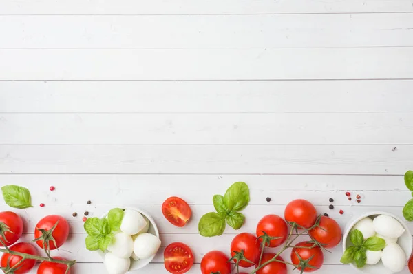 Caprese salatası için malzemeler. Fesleğen, mozzarella topları ve kopya alanı ile beyaz bir arka plan üzerinde domates.