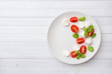 Beyaz tabakta domates, mozzarella peyniri ve Fesleğen caprese salatası. İtalyan mutfağı. Kopyalama alanı