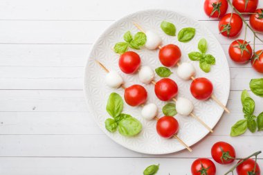 Beyaz tabakta domates, mozzarella peyniri ve Fesleğen caprese salatası. İtalyan mutfağı. Kopyalama alanı