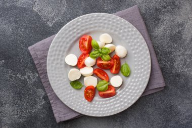Domates Caprese salatası, mozzarella peyniri ve fesleğen koyu bir arka plan üzerinde. İtalyan mutfağı. Kopyalama alanı