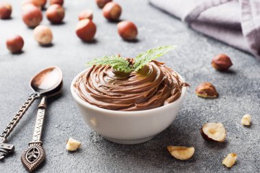 Fındık fındık ile koyu beton arka plan üzerinde bir tabakta Nougat fındık çikolata. Kahvaltı Konsepti.