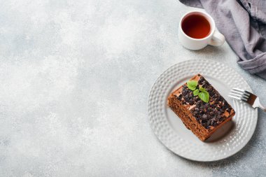 Gri beton arka planda çikolatalı bir parça mantarlı kek. Boşluğu kopyala