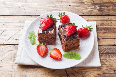 Çilek ve nane ile Çikolatalı trüf kek. Ahşap masa.