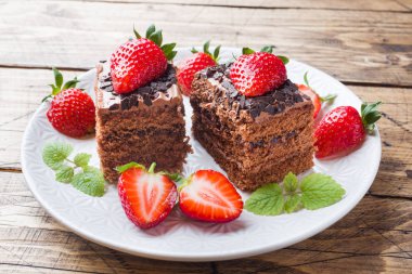 Çilek ve nane ile Çikolatalı trüf kek. Ahşap masa.