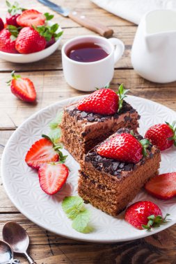 Çilek ve nane ile Çikolatalı trüf kek. Ahşap masa.