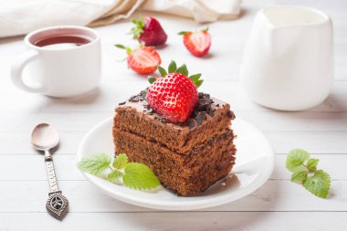 Beyaz ahşap bir masa üzerinde çikolata ve çilek ve nane ile Trüf kek. Seçici odaklama.