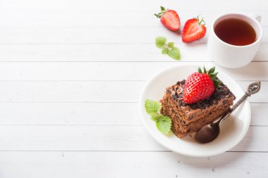 Beyaz ahşap bir masa üzerinde çikolata ve çilek ve nane ile Trüf kek. Seçici odak. Kopyalama alanı